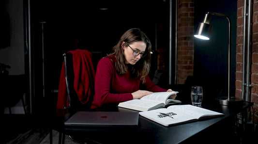 Woman focused in bright home office reading textbook